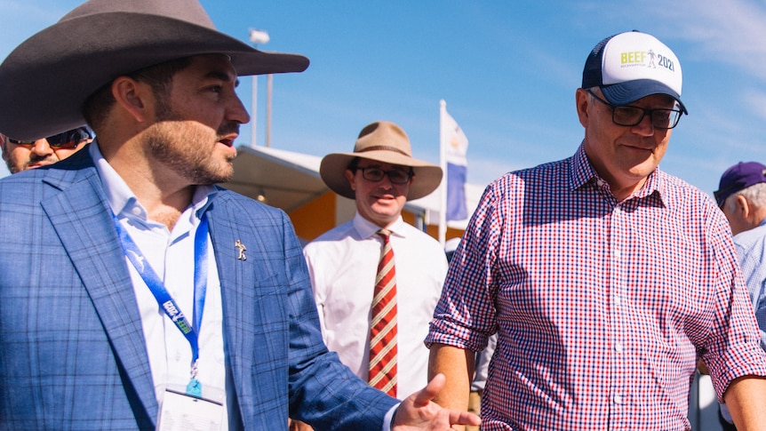 Mid shot of a man in a large cowboy hat speaking to Prime Minister Scott Morrison