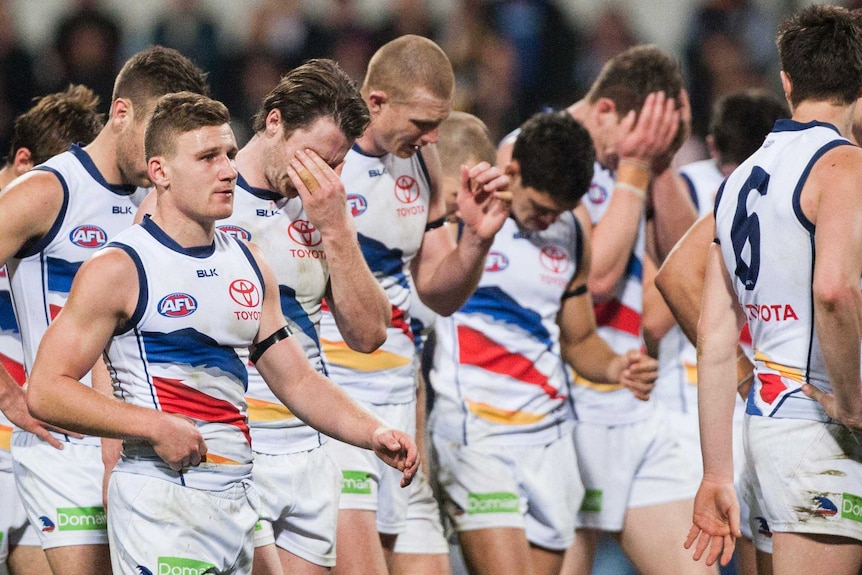 Emotional Crows players after losing to Eagles in their first game since coach Phil Walsh's death.
