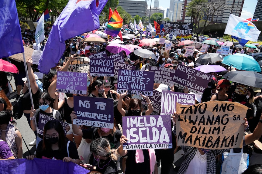 Protesters hold slogans during a rally against presidential frontrunner Ferdinand Marcos Jr