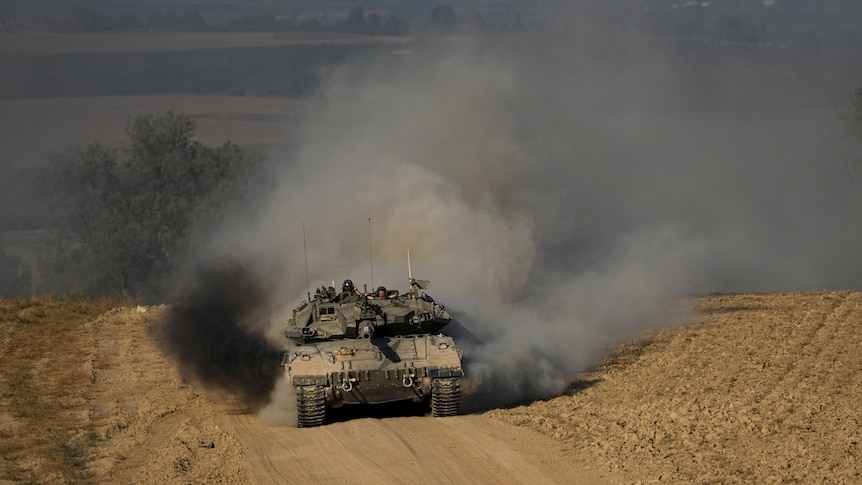 An Israeli tank driving through a dirt road.