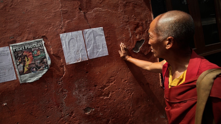 A Tibetan exile reads a note