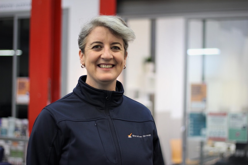 A woman with short grey hair smiles at the camera