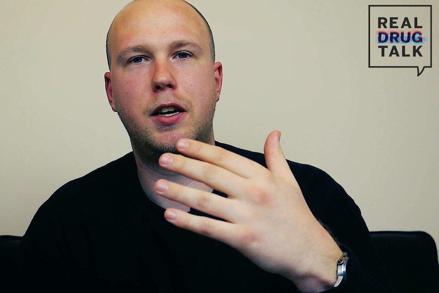 A man with a shaved head gestures