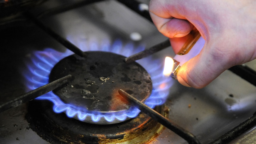 Hand lights a gas stove