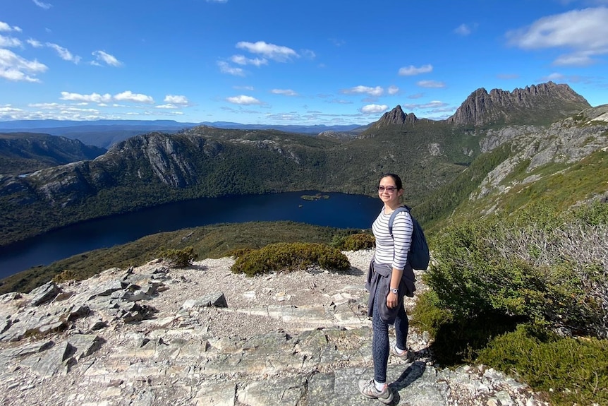 Woman wearing glasses standing on a mountain.