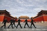 Soldiers wearing protective face masks march past the closed entrance gates to the Forbidden City.