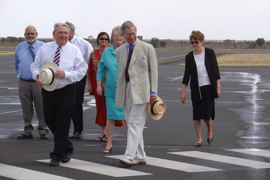 Prince Charles walks with dignatries on an airport tarmac in 2005.