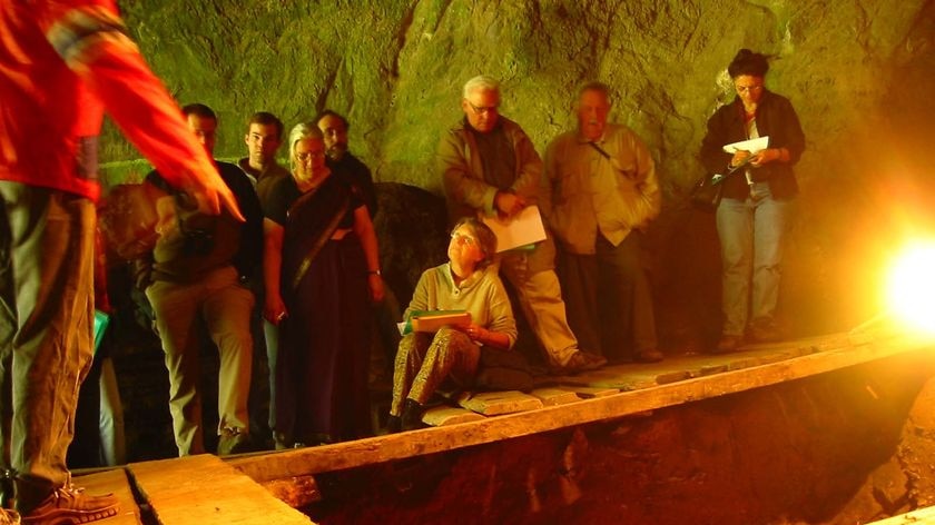 Participants of an archaeological conference gather inside Denisova cave, Siberia