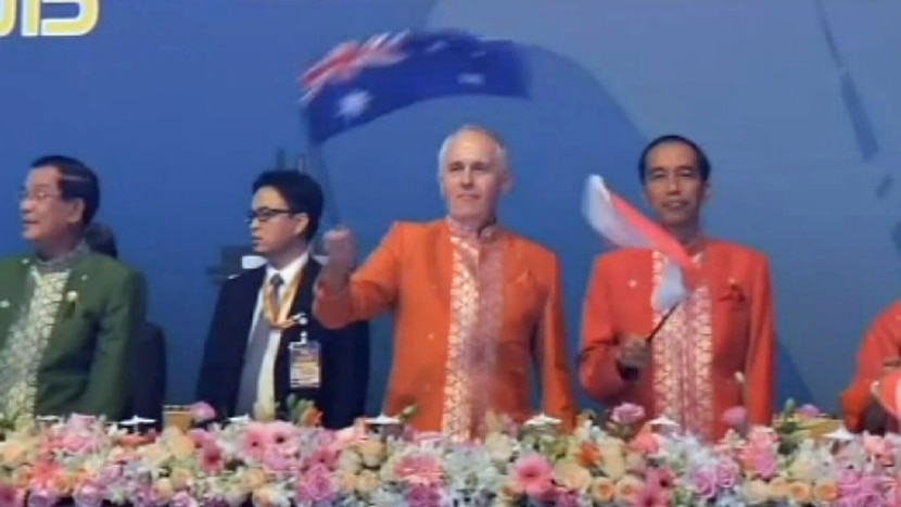 Prime Minister Malcolm Turnbull waving an Australian flag during ASEAN celebrations in Kuala Lumpur on November 22, 2015.