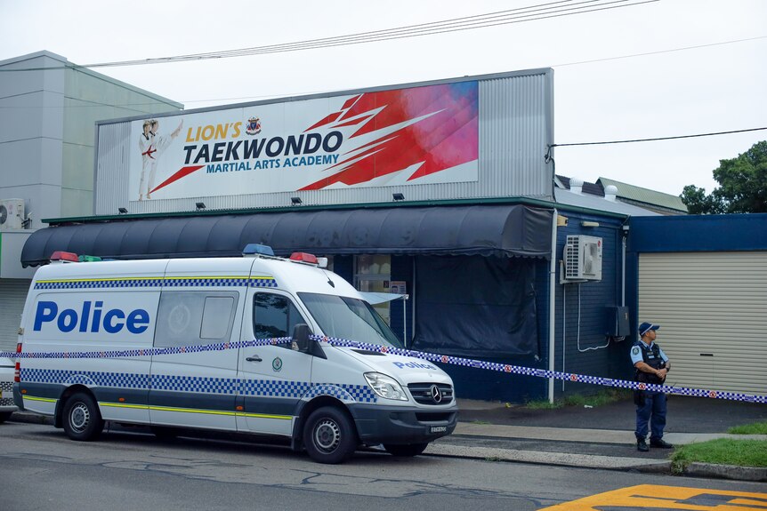 Polizeiwagen und Polizist vor einem abgesperrten Lions-Taekwondo-Studio