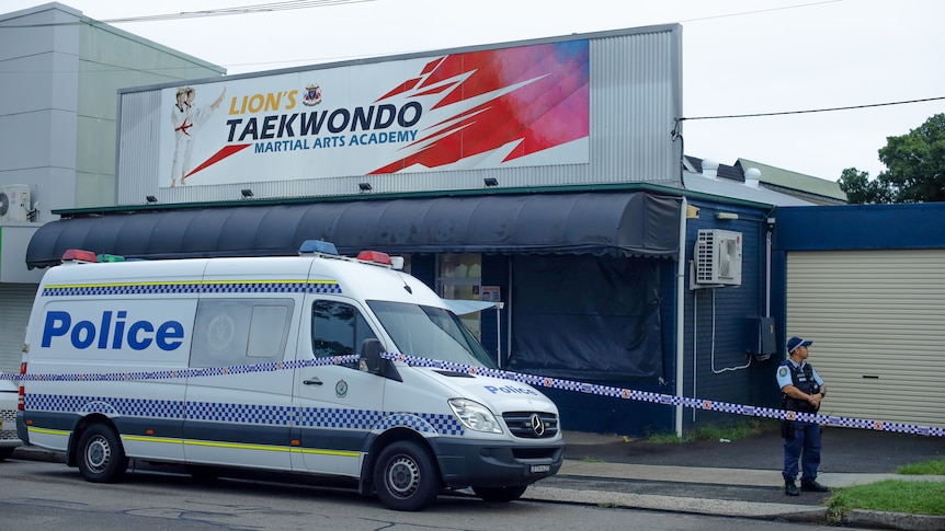 Police van and police man outside a cordoned off Lions Taekwondo studio
