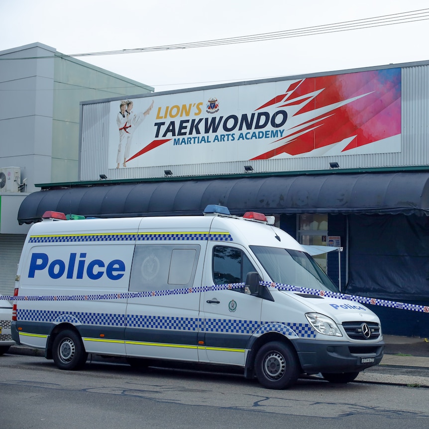 Police van and police man outside a cordoned off Lions Taekwondo studio