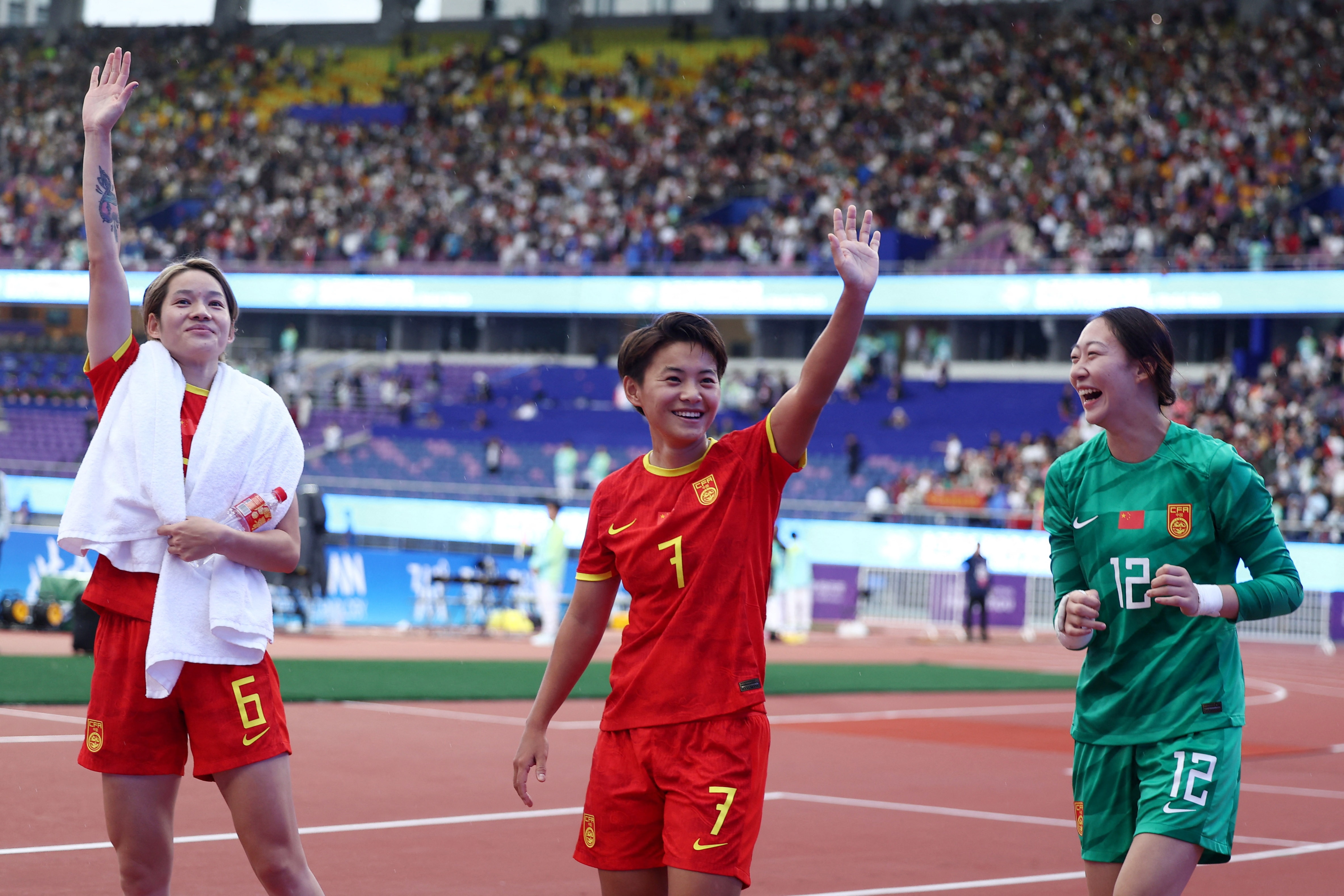 Dois jogadores de futebol acenando para o público.