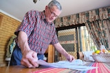 A man looking at papers in a colour top