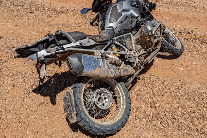 A motorcycle lying on orange dirt