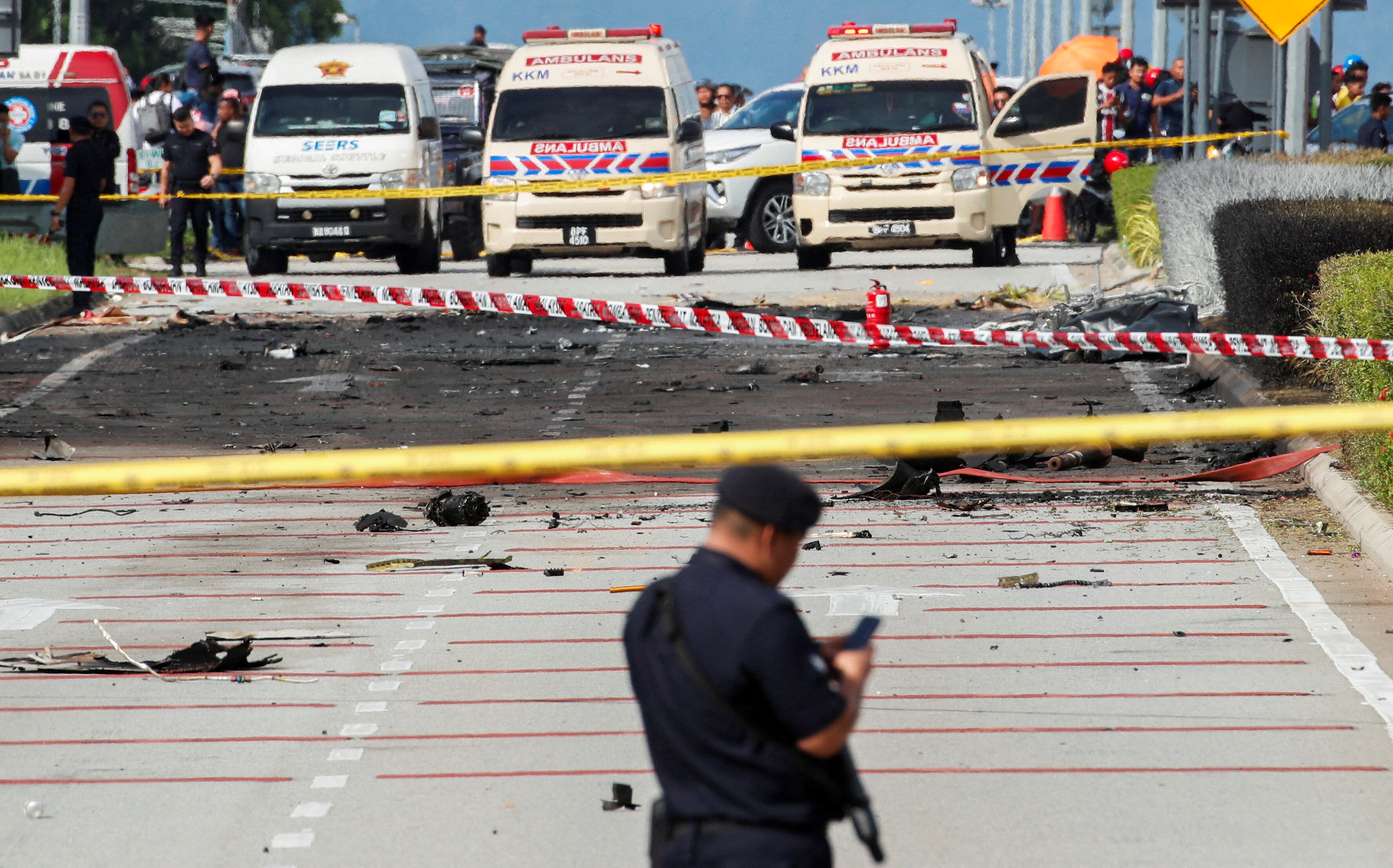 Police stands in front of the site of a plane crash in Malaysia.
