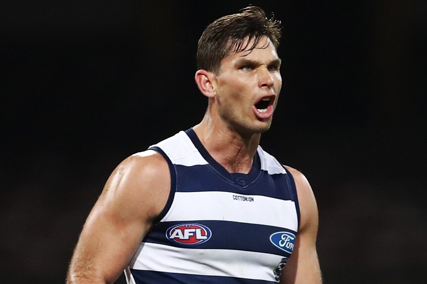 A Geelong Cats AFL player screams as he celebrates kicking a goal against the Brisbane Lions.