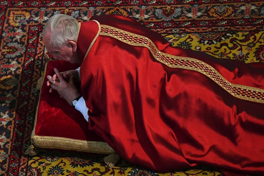 Pope Francis lies down in prayer during the Good Friday Passion of the Christ Mass at the Vatican.