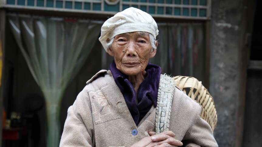 A 91-year-old woman stands on the main street of Changgang, China.