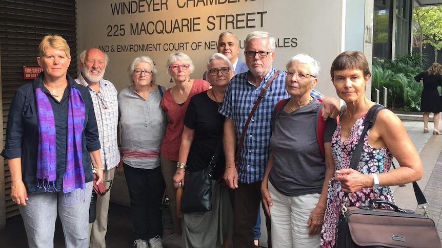 A group of men and women outside a court building.