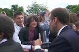 Still from video. Mr Macron holds a one finger up, scolding a teen boy standing in a packed crowd.