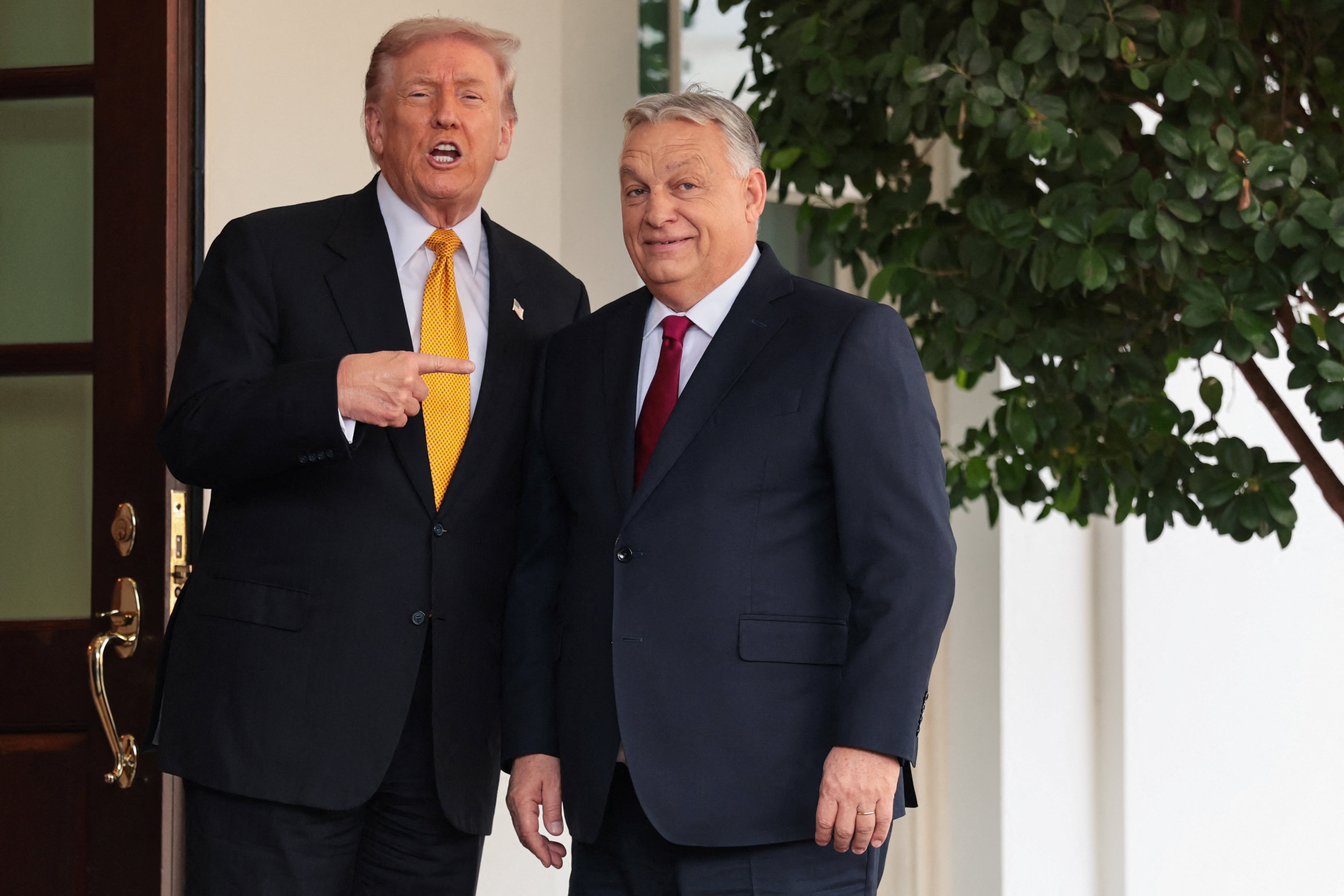Donald Trump greets and points at Hungarian PM Viktor Orban.