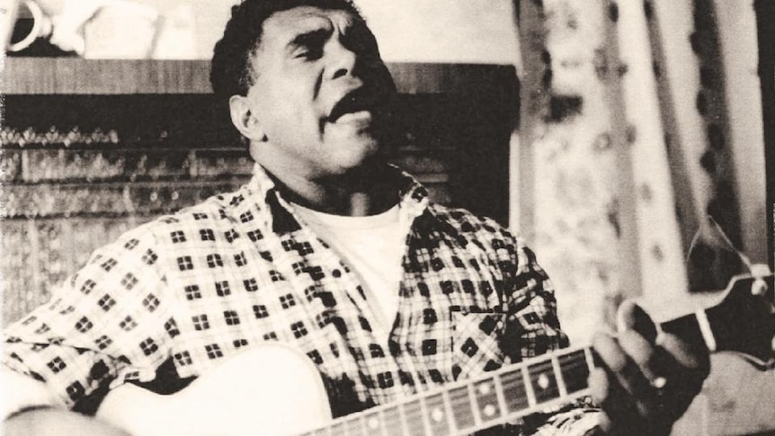 Young Archie Roach plays guitar