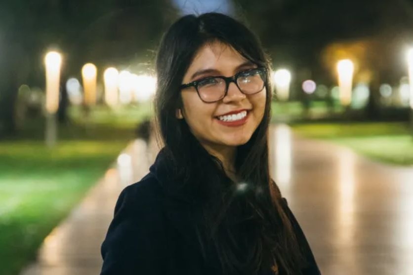 Woman with long hair and glasses at night in park