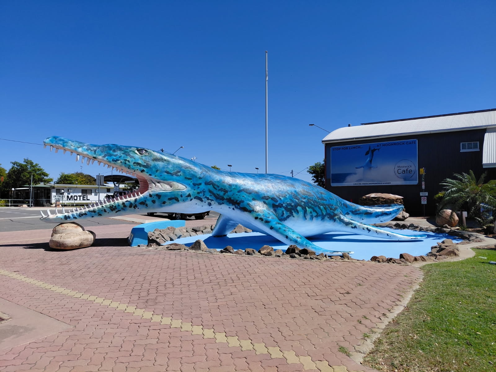Uma estátua gigante de um réptil marítimo pré-histórico fica do lado de fora de um museu no outback.