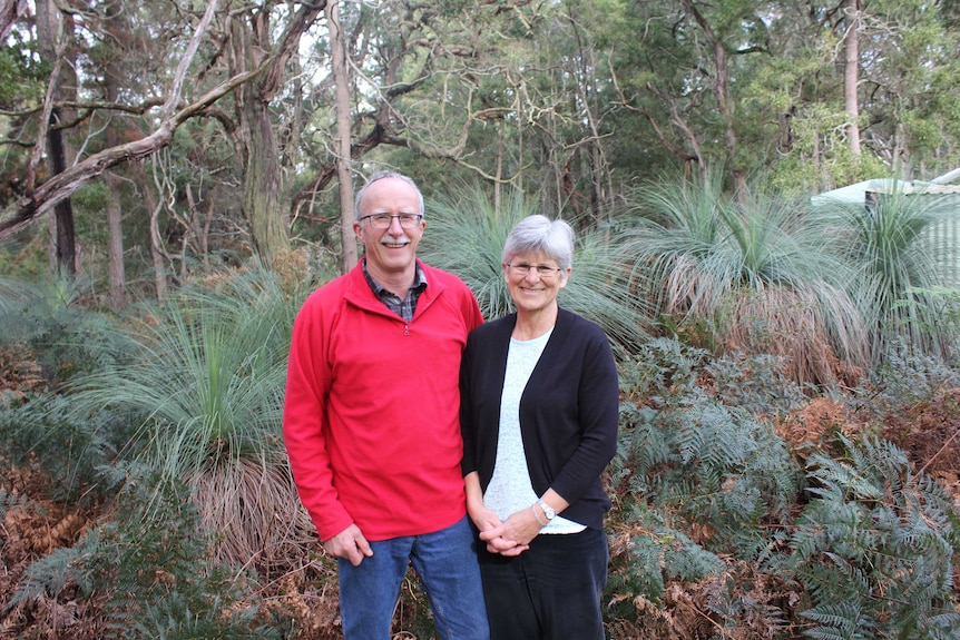 Karen and Stephen standing in the scrub on their property. They are smiling and Stephen has his arm around Karen.
