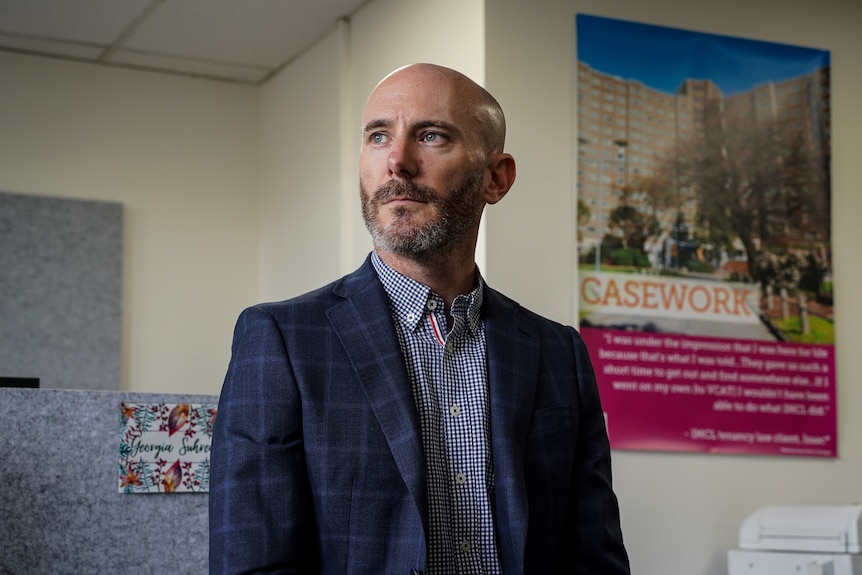 A bald man in a suit sitting in an office