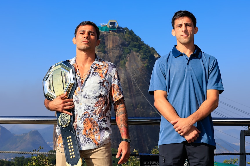 Two fighters pose in front of Sugar Loaf hill in Rio de Janiero 