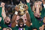 South Africa captain Siya Kolisi holds the Webb Ellis Cup up with teammates after the Rugby World Cup final.