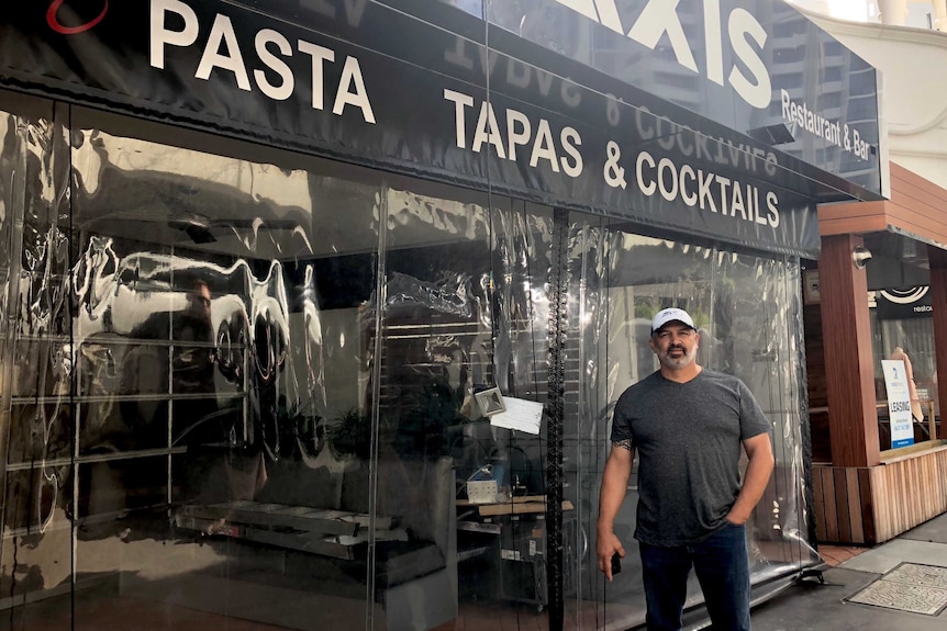 Mr Marhaba stands in front of his empty shop, a sign reads 'pasta and tapas'.