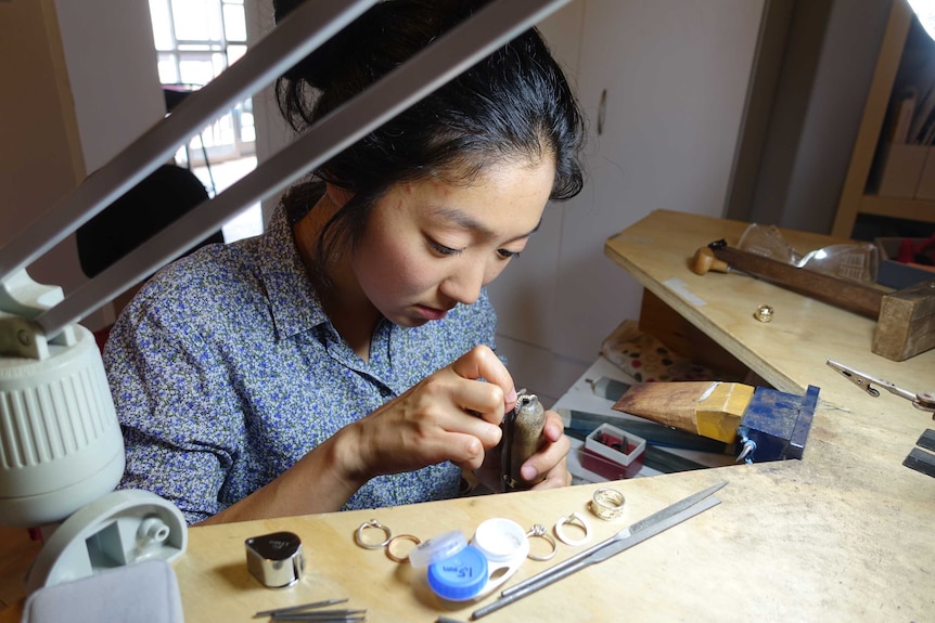 Mana Ohori at a desk using implements to make a ring.