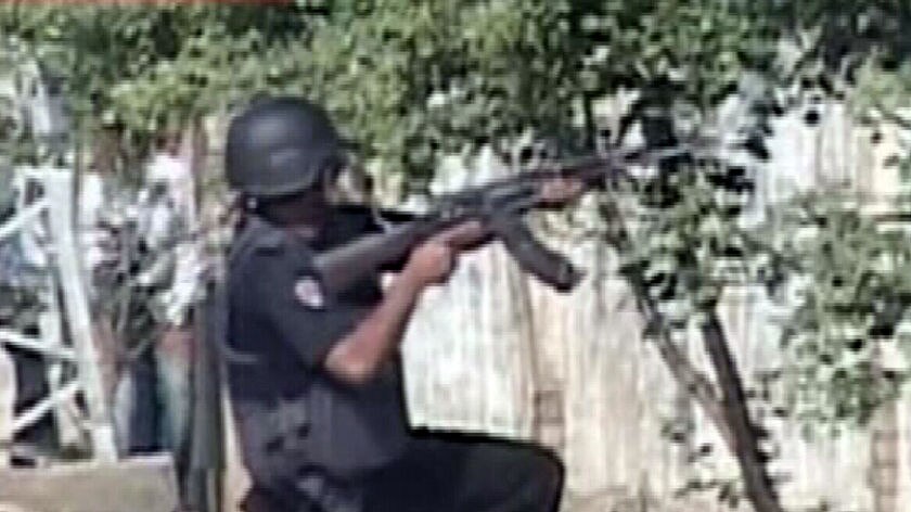 A Pakistani special commando aiming his weapon after gunmen attacked a police training school.