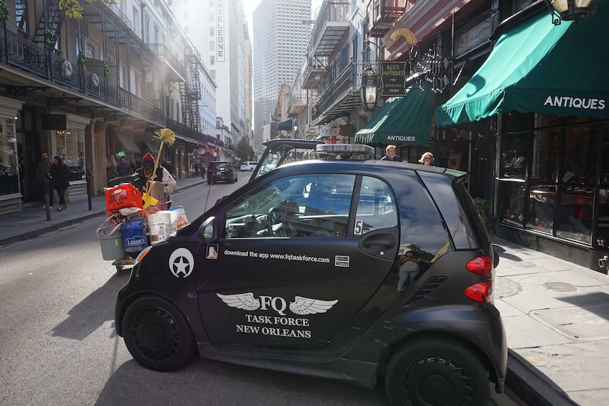 A small security car parked in front of a pan handler