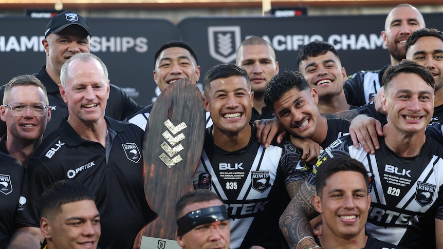 Kiwis players and coaches celebrate defeating the Kangaroos in the Pacific Championships final.