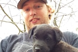 Jason Challis, who was killed during live-fire training, is pictured with a black puppy.