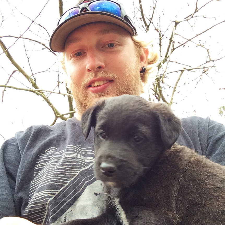 Jason Challis, who was killed during live-fire training, is pictured with a black puppy.