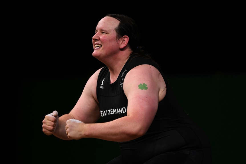 A woman wearing a New Zealand team singlet.