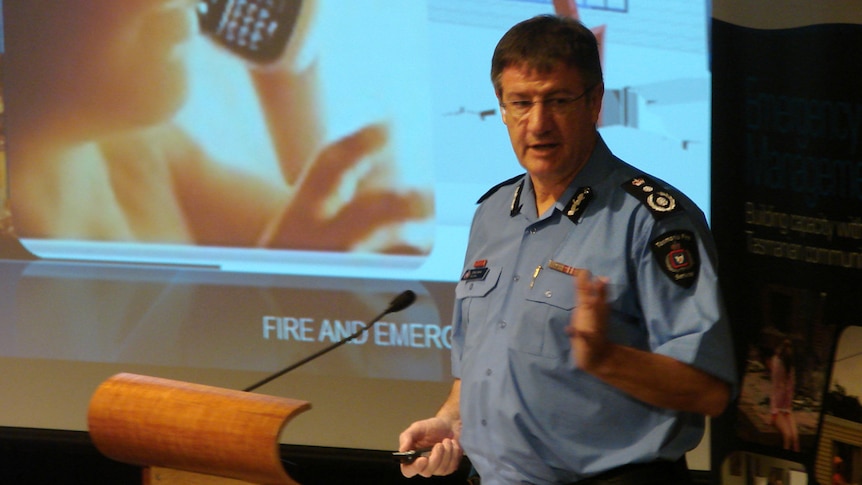 Tasmanian Fire Service chief Chris Arnol on stage behind a podium