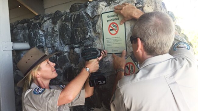 Rangers erect a no smoking sign in a picnic area