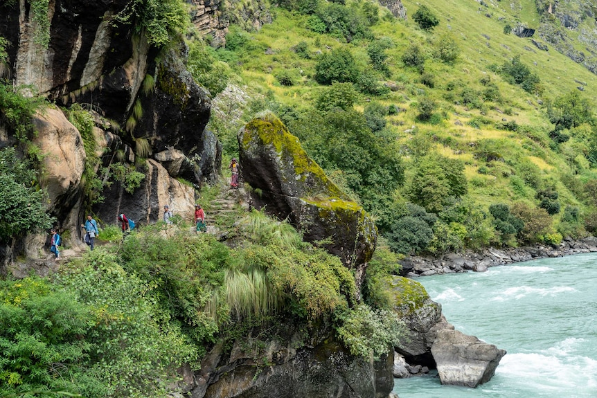 The group walks past a river.