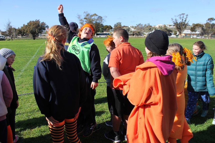 A young boy leads the cheer at the School of the Air athletics carnival.