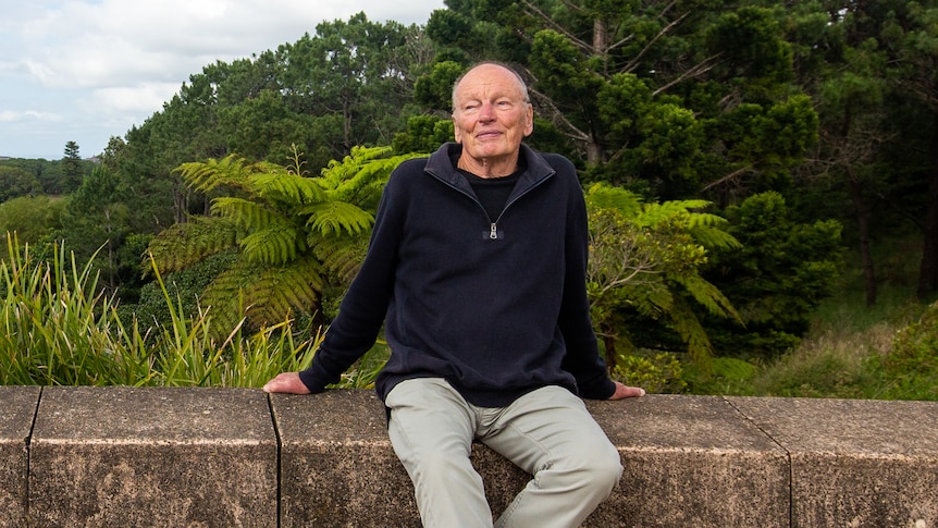 John Bell sits outside in a park