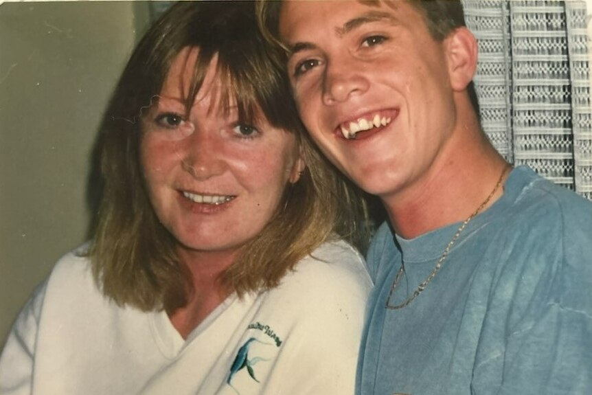 A smiling woman and her teenage son.