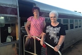 Two Women pose in front of a train called the Savannahlander in Forsayth