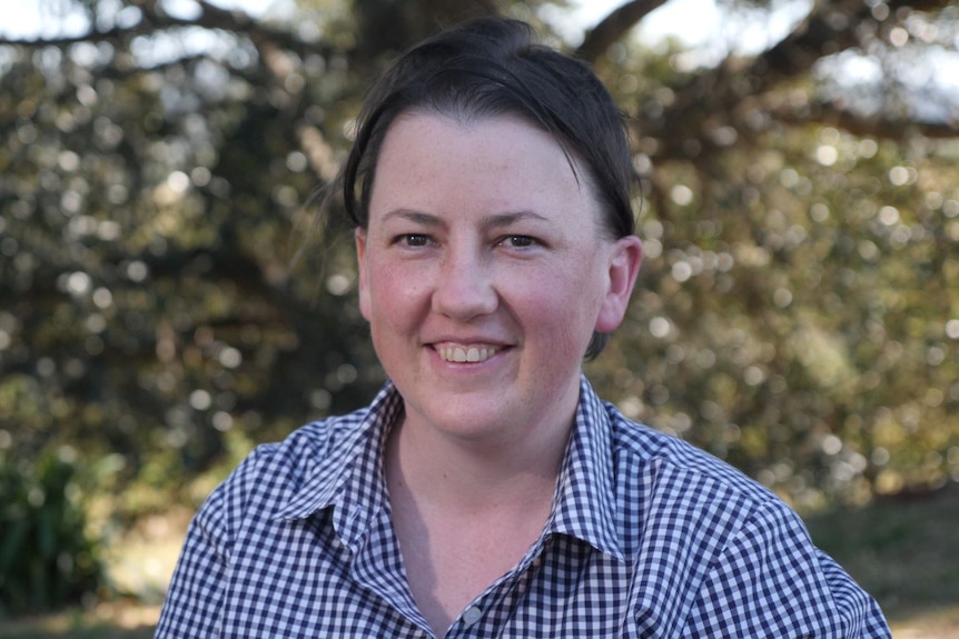 A woman wearing a checked collared shirt.