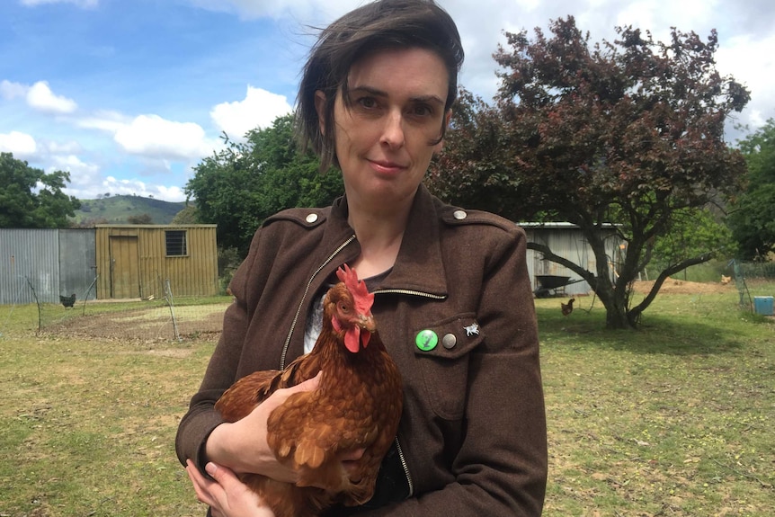 Tamara Kenneally holds a chicken in her arms